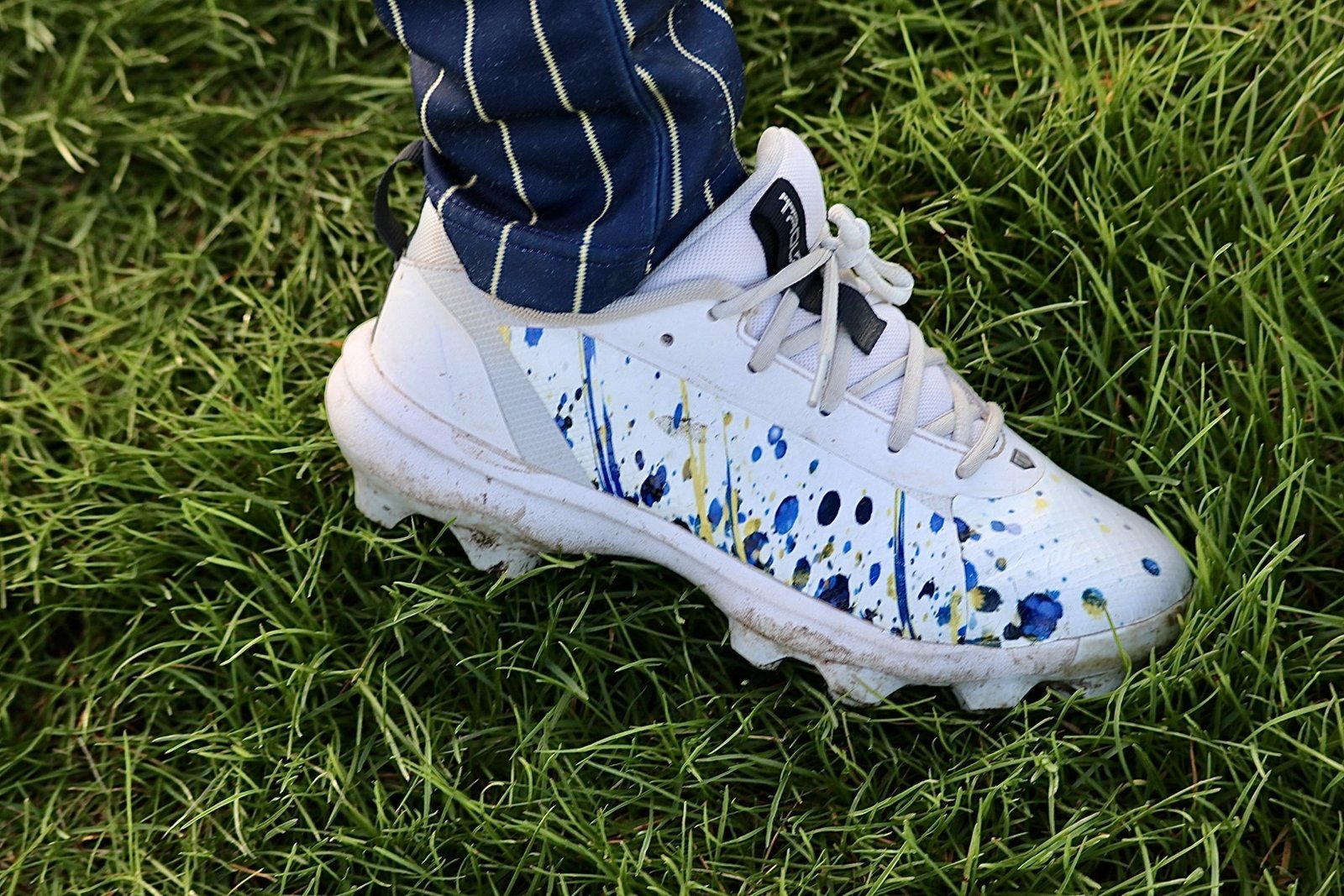 Close-up of a custom TAKX wrapped baseball cleat