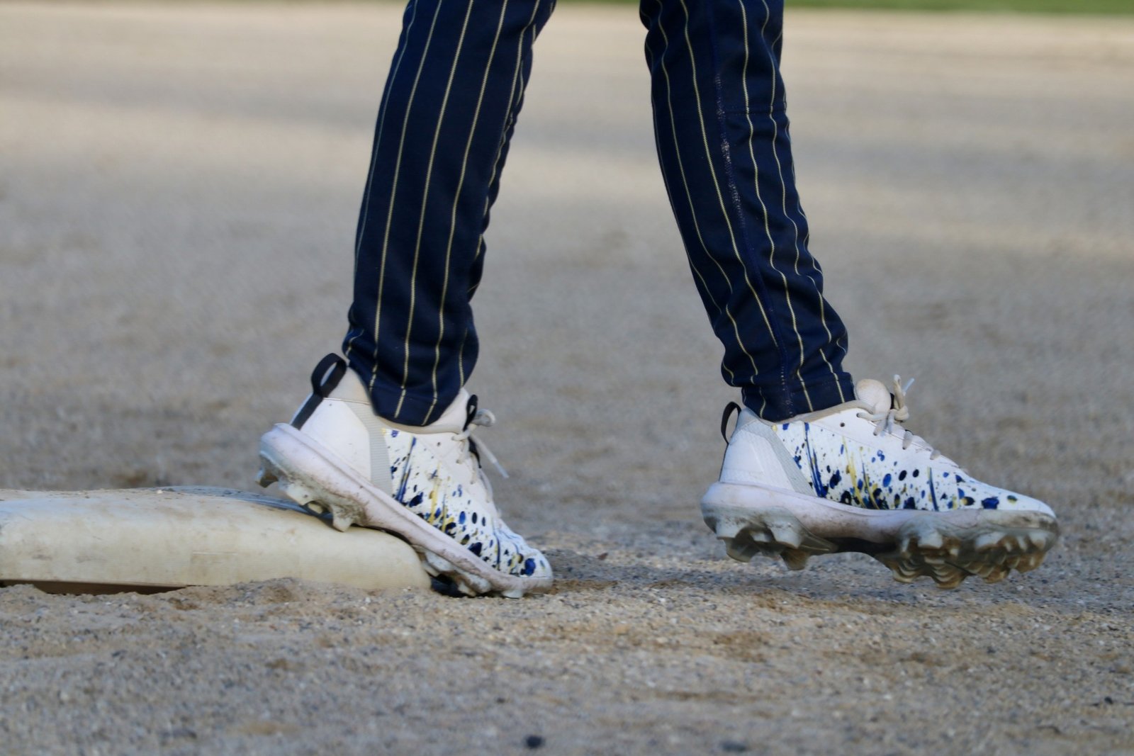 Custom TAKX wrapped baseball cleats on the field